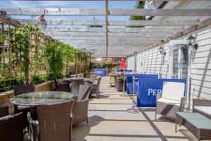 an outdoor patio with tables and chairs and a pergola at The Angel Hotel in Alton