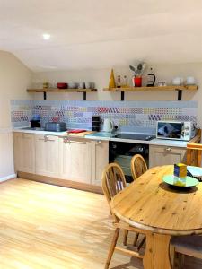 eine Küche mit einem Holztisch und einem Tisch und Stühlen in der Unterkunft Sandpipers Cottage - Devon Sleeps 4, Garden, rural, Dog friendly in Holsworthy