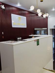 a white counter with a sign on a wall at Mildom Hotel in Almaty