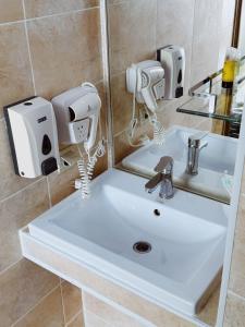 a bathroom with a white sink and a mirror at Mildom Hotel in Almaty
