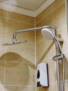 a shower with a shower head in a bathroom at Mildom Hotel in Almaty +33 photos