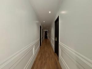 um corredor vazio com paredes brancas e pisos de madeira em D and D hotel em Tbilisi
