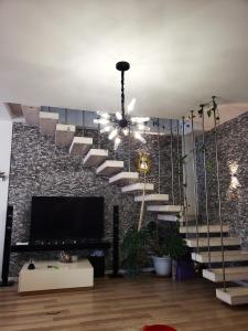 a living room with a staircase with a chandelier at 2 bedroom duplex Durrës in Durrës