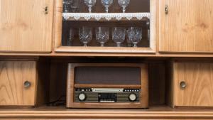 una vieja radio en un armario con copas de vino en Ferienwohnung Kirsche - Obsthof Steffelin, en Heraclión