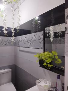 佩拉德尼亞的住宿－Ella Way Resort，浴室配有卫生间,墙上挂有鲜花