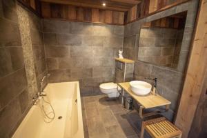 a bathroom with a sink and a toilet and a tub at Chalet Jean (Coeur de Morzine) Jacuzzi & Sauna in Morzine