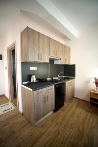 a kitchen with wooden cabinets and a black counter top at Zante Art de l'eau in Zakynthos Town