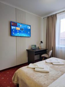 a hotel room with a bed and a desk and a television at Fine Ap4youIF in Ivano-Frankivsʼk