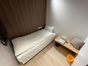 a small room with a bed and a night stand at Twin Star Inn in Taipei