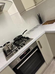 a kitchen with a stove with a pot on it at Cardiff Grangetown Stylish 3Bed House. in Cardiff