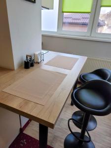 a wooden table with two black chairs in a room at Fine Ap4youIF in Ivano-Frankivsʼk