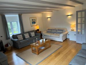 uma sala de estar com dois sofás e uma mesa de centro em Spring Barn at Bolberry Court em Hope-Cove