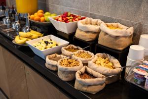 uma linha de buffet com tigelas de comida e taças de fruta em Holiday Inn Express - Concepcion, an IHG Hotel em Concepción