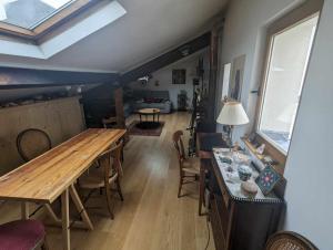 a living room with a wooden table and chairs at Loft cosy et lumineux à Paris,Les Lilas dans un quartier convivial proche du métro 11 "Mairie des Lilas" et du tram T3b "porte des Lilas" in Bagnolet