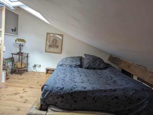 a bedroom with a bed with a blue comforter at Loft cosy et lumineux à Paris,Les Lilas dans un quartier convivial proche du métro 11 "Mairie des Lilas" et du tram T3b "porte des Lilas" in Bagnolet