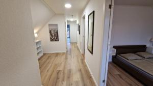 a hallway of a room with a bed and wooden floors at Apartments in Smålandsstenar in Smålandsstenar