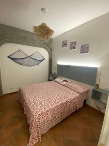 - une chambre avec un lit et une peinture murale dans l'établissement Casa TYSANDROS Due passi dal mare, à Giardini Naxos