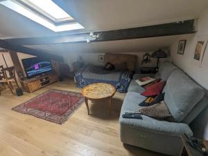a living room with a couch and a bed at Loft cosy et lumineux à Paris,Les Lilas dans un quartier convivial proche du métro 11 "Mairie des Lilas" et du tram T3b "porte des Lilas" in Bagnolet