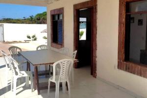 een tafel en stoelen op een patio met uitzicht op de oceaan bij Hostel Summer Praia do Sol in João Pessoa