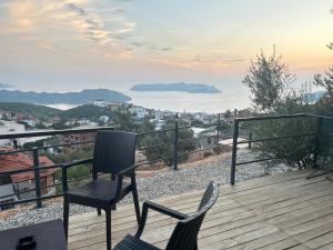 two chairs on a deck with a view of a city at Ay-Ra Bungalow Suite in Kaş