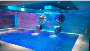 a swimming pool with blue lights in a building at Snow White in Veliko Gradište