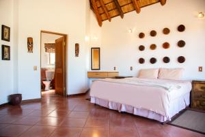 a bedroom with a large bed and a bathroom at Sondela Nature Reserve & Spa Makhato Lodges in Bela-Bela
