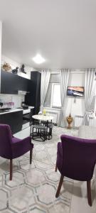 a living room with purple chairs and a table at parkent plaza apartments in Tashkent