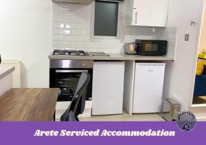 an apartment kitchen with a stove and a microwave at 3 bed Accommodation perfect for Workers & Families requiring weekly or Monthly Nest in Woolwich