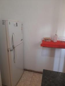 a kitchen with a white refrigerator and a red shelf at Apart incone in Formosa
