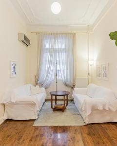 uma sala de estar com dois sofás brancos e uma mesa em #Magnolia Apt by halu! Apartments em Tessalônica