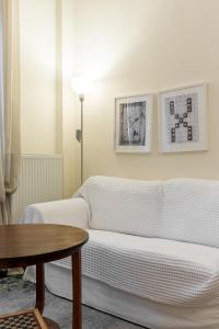uma sala de estar com um sofá branco e uma mesa em #Magnolia Apt by halu! Apartments em Tessalônica