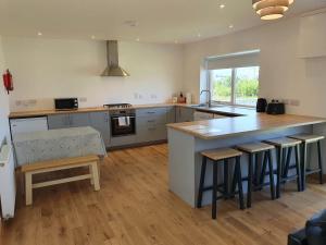 a kitchen with a large island with bar stools at Bayview 1-Bed Cottage in Isle of Lewis in Bragor