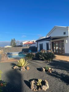 ein Haus mit vielen Pflanzen im Hof in der Unterkunft Faro Park Villa Bella heated Pool in Playa Blanca