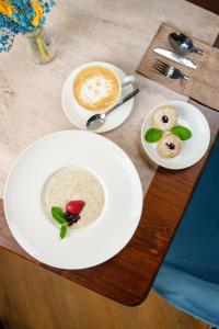 una mesa con dos platos de comida y una taza de café en Dami Astana Hotel en Astaná