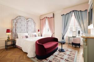 1 dormitorio con 1 cama grande y 1 silla roja en The Leo Grand, en Viena