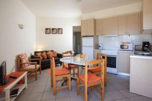 cocina y sala de estar con mesa y sillas en New Kydonia Apartment 30 en Kato Daratso