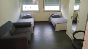 a small room with two beds and a couch at Viva Zimmer in Heilbronn Zentrum in Heilbronn