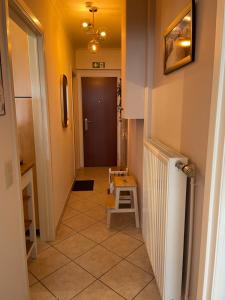 um corredor com uma porta e uma escada com um banco em Zeezicht Studio Delphine em Blankenberge