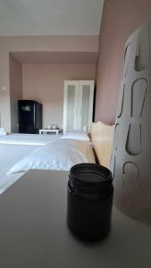 a bedroom with a large bed with a black pot on the floor at Meerithic ROKKA ROOMS in Vourvourou