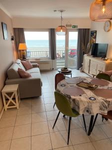 uma sala de estar com uma mesa e um sofá em Zeezicht Studio Delphine em Blankenberge