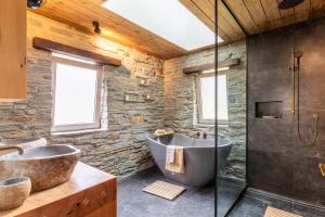 a bathroom with two sinks and a large tub at Stone Cottage in Arrowtown
