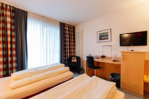 a hotel room with a bed and a desk at Landhotel Gasthof Drexler GbR in Fürstenfeldbruck