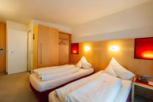 a hotel room with two beds in it at Landhotel Gasthof Drexler GbR in Fürstenfeldbruck