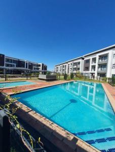 a large swimming pool in front of a building at White Oasis in Gaborone