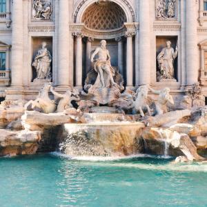 een fontein voor een gebouw met beelden bij Vatican rooms in Rome