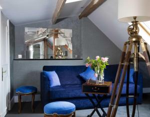 a blue couch in a living room with a mirror at Hotel & Spa de Latour Maubourg in Paris