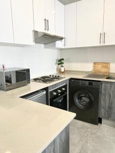a kitchen with a washing machine and a stove at White Oasis in Gaborone