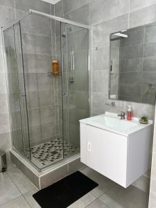 a bathroom with a shower and a sink at White Oasis in Gaborone