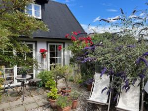 a house with a patio with plants and flowers at Huset i gränden - granne med havet in Trelleborg