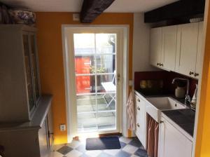 a kitchen with a door leading to a patio at Huset i gränden - granne med havet in Trelleborg